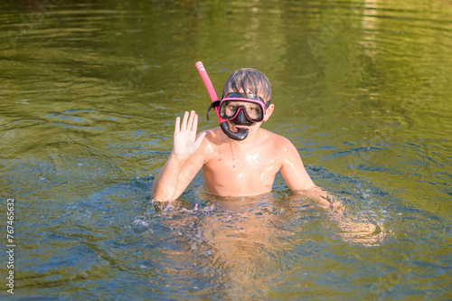 Child bathing in pink mask in water in summer. High quality photo