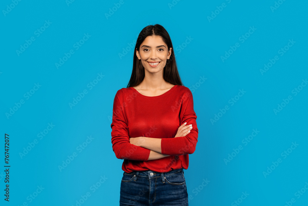 Confident Woman With Crossed Arms Standing Against Blue Background Confident Woman With Crossed Arms Standing Against Blue Background