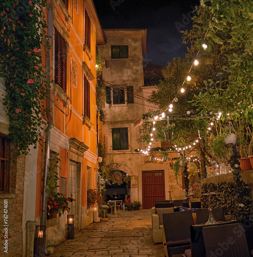 Old street in Porec town illuminated by lamps at the evening, Croatia, Europe