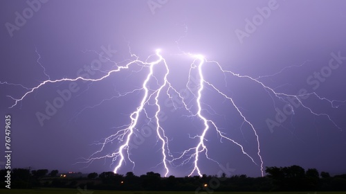  a group of lightning strikes in the sky above a field of grass and trees in front of a dark purple sky.