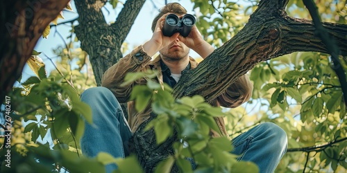 Man in tree with binoculars - treetop pervert - peeping tom photo