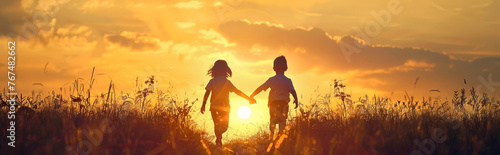 Golden sunset with two children walking hand in hand towards the sun