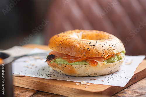 Gourmet Bagel with Smoked Salmon and Cream Cheese on Wooden Table photo