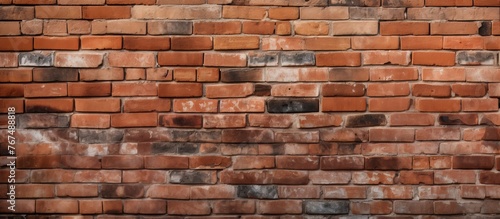 Closeup of a brown brick wall showcasing the intricate pattern and texture of the rectangular building material. A beautiful display of brickwork art on the facade
