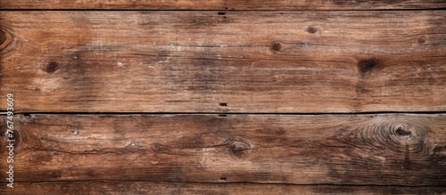 A close up of a brown hardwood plank flooring with a wood stain. The pattern of the wood grain is visible on the beige wooden surface