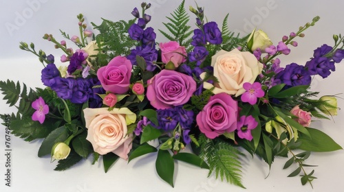  a close up of a bouquet of flowers on a white surface with purple and pink flowers in the center of the bouquet. © Olga