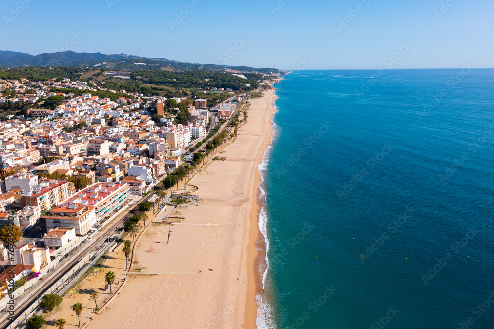 Birds eye view of Canet de Mar, Spain. Residential building along Mediterranean sea coast and beach visible from above.