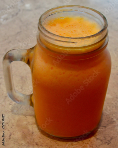 A mango smoothie on the table ready to drink.