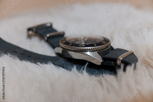 Cuadro en lienzo A circular watch with a gray strap on a shaggy carpet.