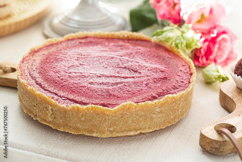 Delicious Homemade Raspberry Tart on a Wooden Table with Rustic Utensils and Flowers  Organic healthy food