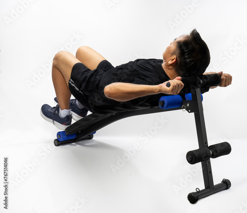 Health and fitness concept, man doing abs exercise or crunches or situps on abs machine on white backghround.