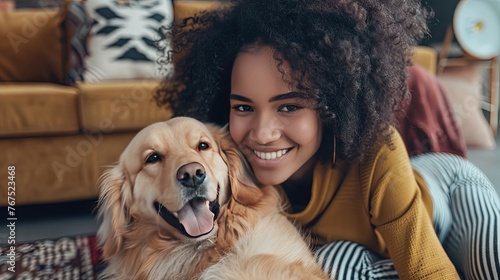 Young Millennial woman cuddles her dog in the living room floor photo
