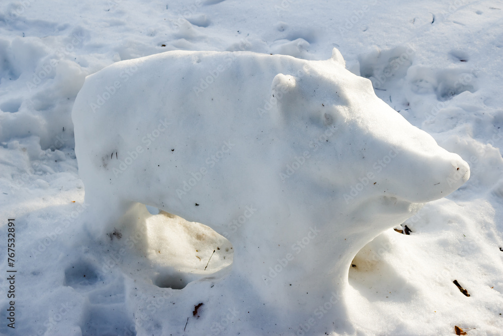 Naklejka premium Figure of a wild boar made from snow in the park