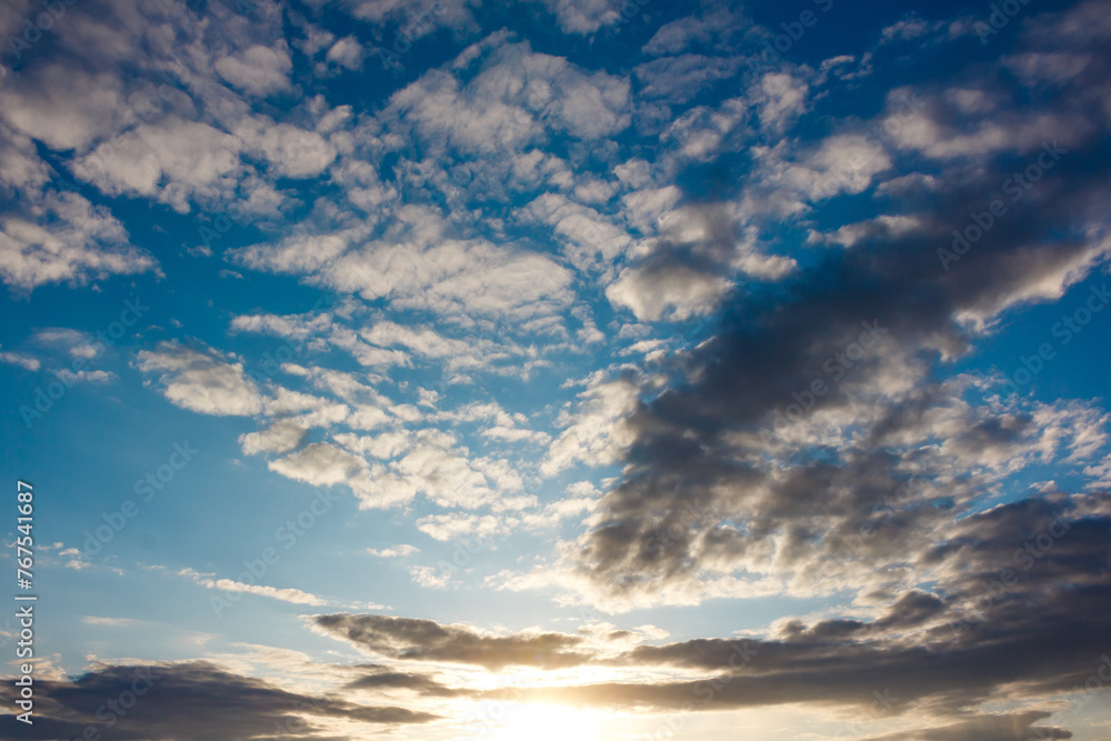 Fototapeta premium Beautiful blue sky with floating clouds at sunset background