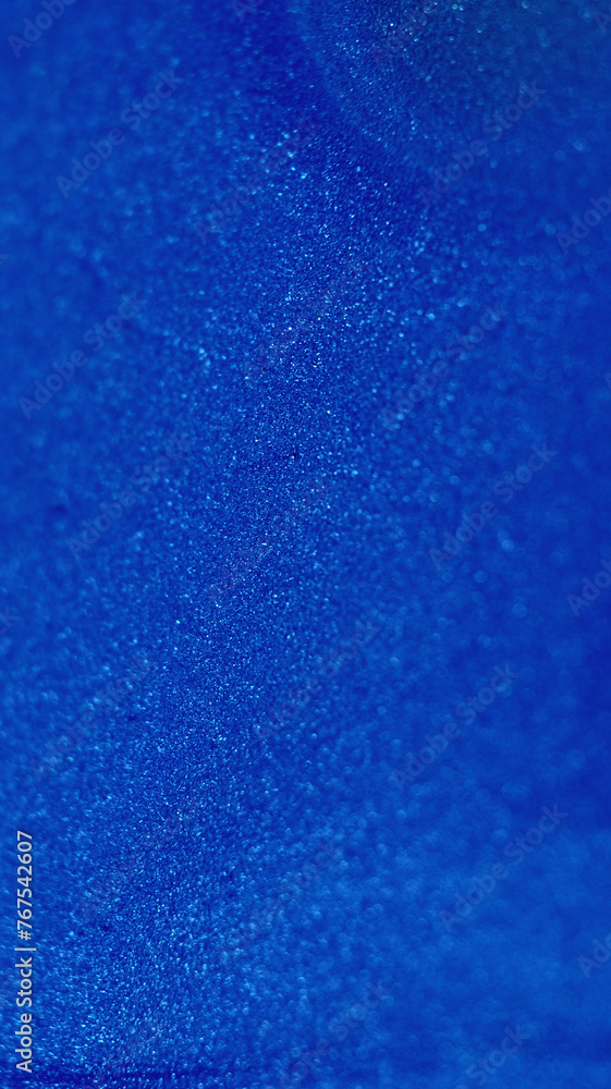 Blue glitter. Shimmering texture. Bokeh circles. Defocused glowing sand crystals ink glamour cold abstract art copy space background.