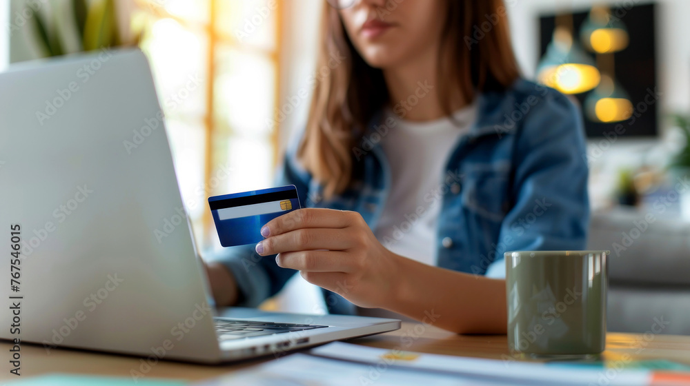 A woman is using a laptop to pay for something with a credit card. A woman is using a laptop to pay for something with a credit card.