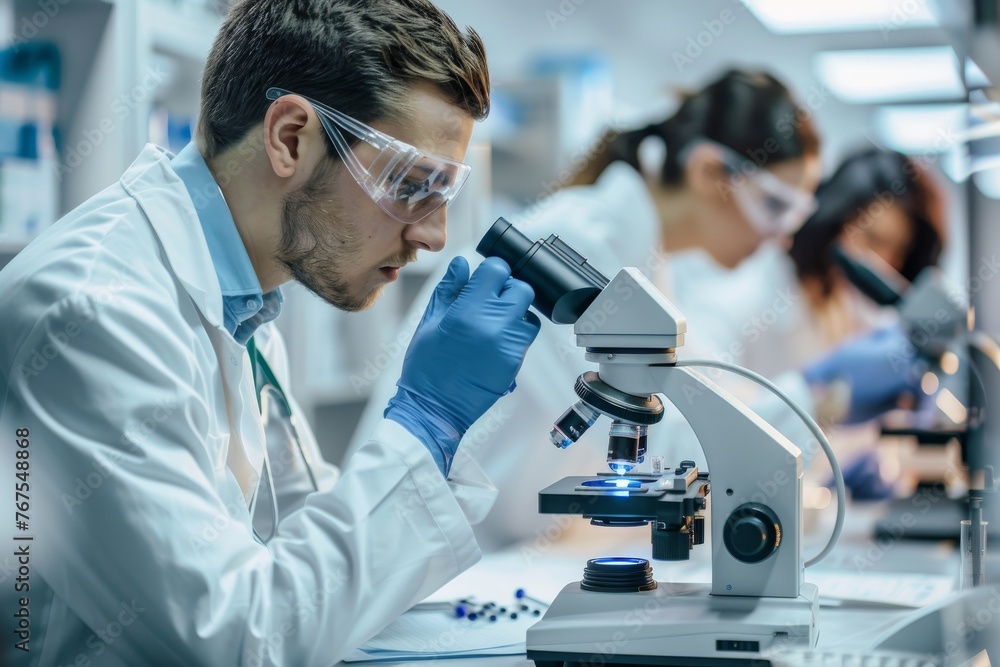 Scientists working with microscopes in a laboratory Scientists working with microscopes in a laboratory
