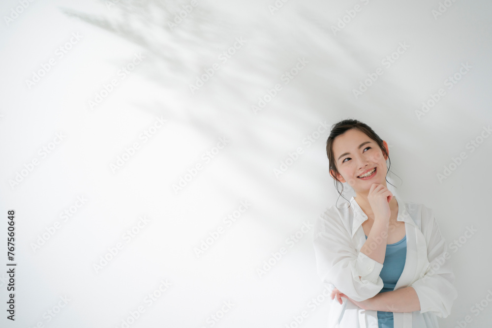 顎に手を当てて考える若い女性 顎に手を当てて考える若い女性