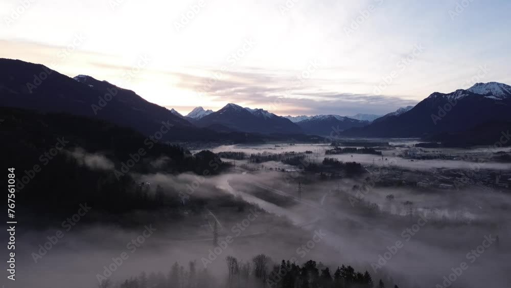 Drone fly above misty pine forest with Aerial Drone View over cityscape in Frastanz, Austria, Sunrise above foggy winter mountain landscape Drone fly above misty pine forest with Aerial Drone View over cityscape in Frastanz, Austria, Sunrise above foggy winter mountain landscape