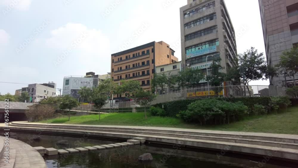 Urban park with a pond in foreground, modern buildings in the background, overcast day Urban park with a pond in foreground, modern buildings in the background, overcast day