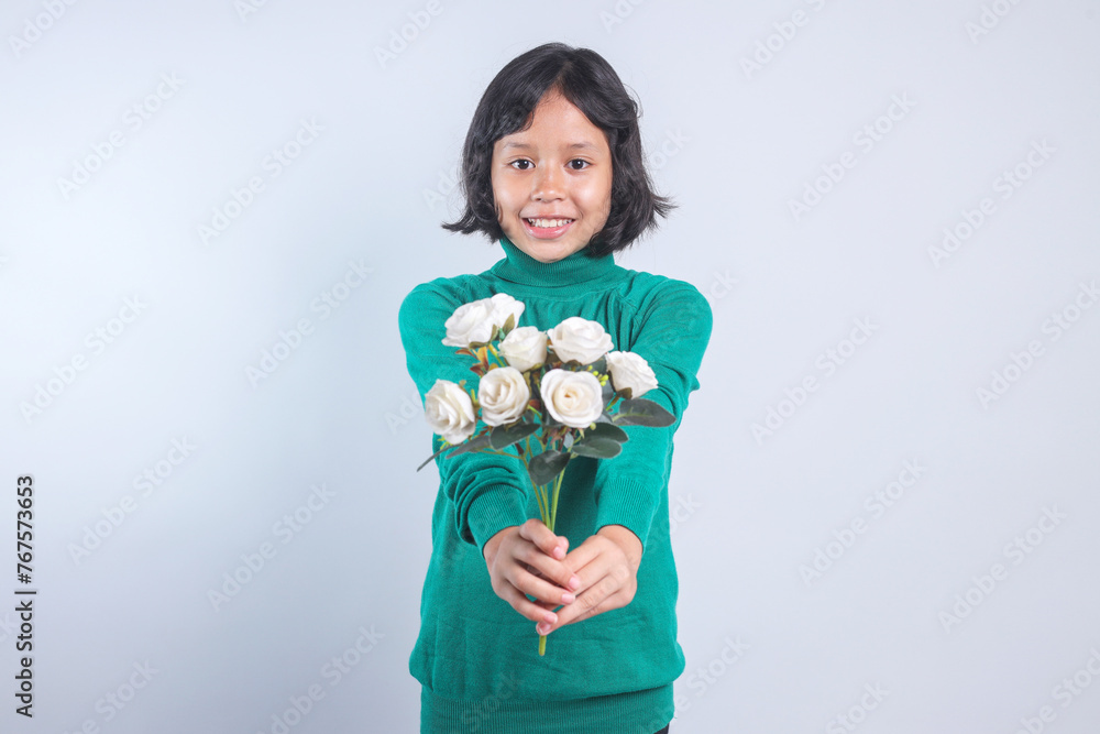 Portrait of Asian little girl holding a bouquet of white roses flower on grey background. Portrait of Asian little girl holding a bouquet of white roses flower on grey background.