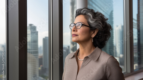 mature optimistic Indian businesswoman woman female executive CEO in corporate modern office thinking contemplating and looking out window skyscraper cityscape daytime with room for text Free Download mature optimistic Indian businesswoman woman female executive CEO in corporate modern office thinking contemplating and looking out window skyscraper cityscape daytime with room for text - GFXLoad