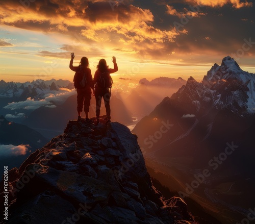 Two people are standing on a mountain peak  waving to each other