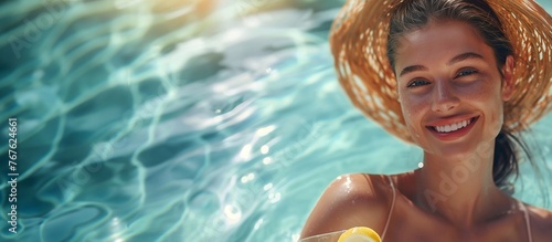 Charming cute happy woman looking at the camera with a joyful gaze on a banner with the water surface of a pool or sea. Free time in summer for vacation to improve mental health