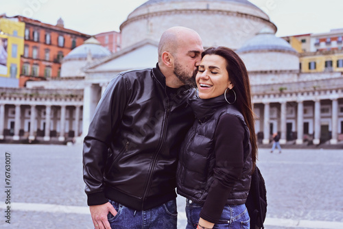 Happy smiling beautiful  Tourists  couple traveling at  Naples Italy, poses and making photos  in front of  Piazza del Plebiscito , Italy.Concept of Italian gastronomy and travel. Italian couple  © Striker777