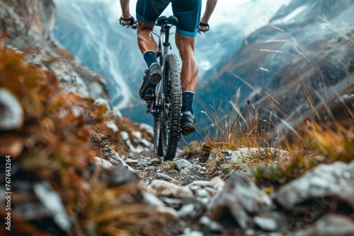 Close-up view of legs and shoes while riding on mountain trails, emphasizing the physicality and adventure of mountain biking © Nattadesh