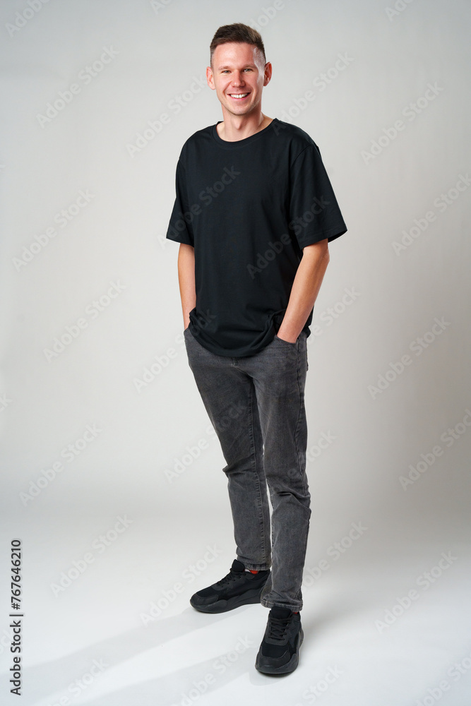 Full length portrait of young smiling man wearing casual clothes on gray background Full length portrait of young smiling man wearing casual clothes on gray background