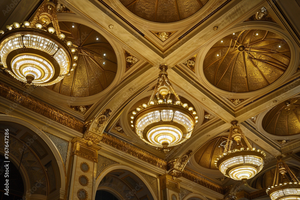 An opulent ceiling with a series of gold-leafed domes, each featuring a central, ornate chandelier, evoking the grandeur of a bygone era.