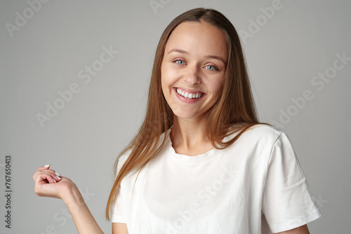 Portrait of a young woman in white T-shirt on gray background