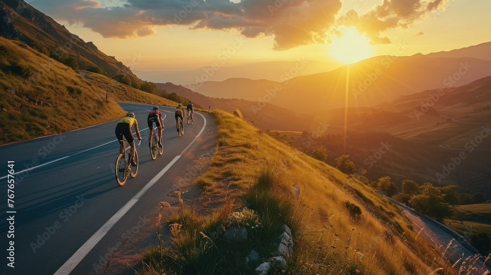 Fototapeta premium Group of cyclist ride together on road bicycles in beautiful nature. Sunset light, sea in background