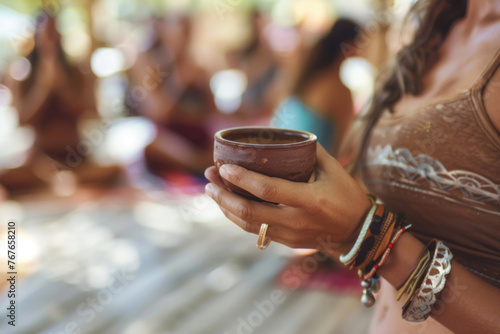 Cacao ceremony, hands of female yoga teacher on Ibiza island, holding a cup of pure organic ceremonial cacao drink.