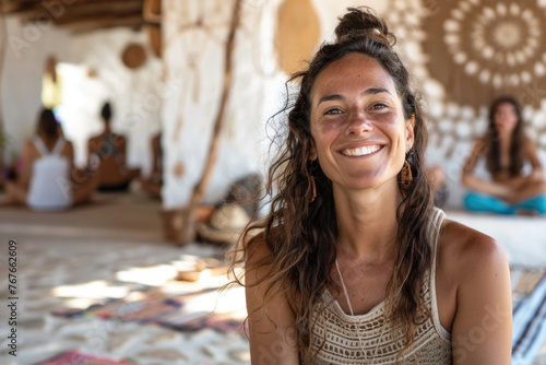 Portrait of a happy and smiling yoga teacher on Ibiza island, holding cacao drink in ceramic cup. Blurred people in the background photo