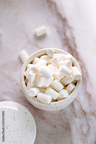 cup with small marshmallows close-up on a light background