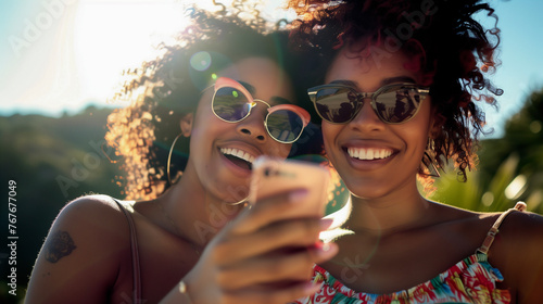 two African American women looking into their smart phone screen photo