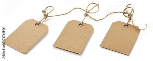 Three tags are hanging from a string. The tags are brown and have a tag on them