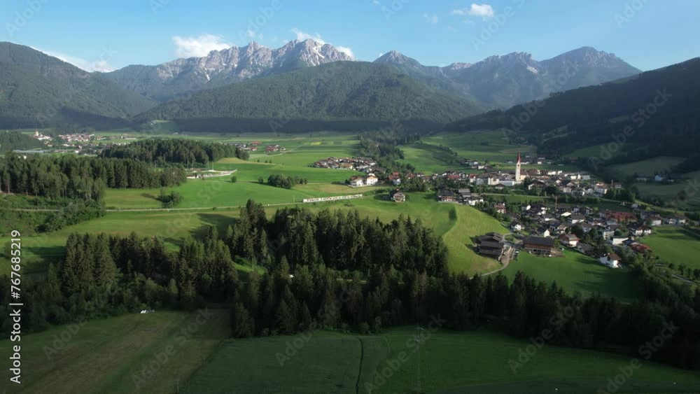 Aerial view of a tranquil village surrounded by forests and mountains in the Alps, Dolomites, Toblach, Dobiacco, South Tirol, Italy Aerial view of a tranquil village surrounded by forests and mountains in the Alps, Dolomites, Toblach, Dobiacco, South Tirol, Italy
