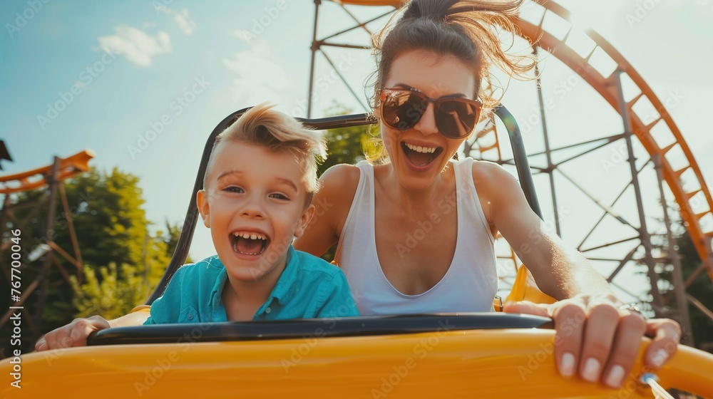 A woman and a boy are riding a roller coaster. Scene is joyful and fun