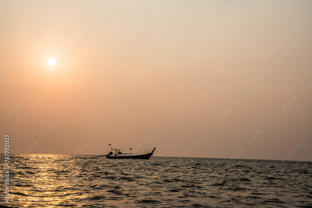 drewniana łódka na tle zachodzącego słońca - obrazy, fototapety, plakaty 