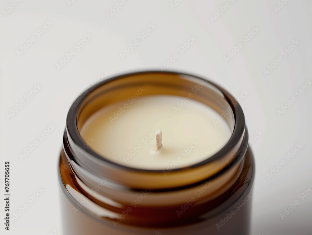 A candle is lit in a glass jar. The candle is lit with a wick and is surrounded by wax. The jar is brown and has a clear top. The candle is the main focus of the image, and it creates a warm A candle is lit in a glass jar. The candle is lit with a wick and is surrounded by wax. The jar is brown and has a clear top. The candle is the main focus of the image, and it creates a warm