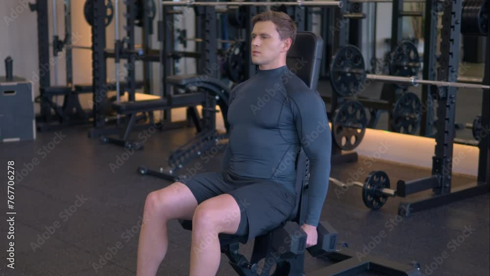 Fit athletic man doing dumbbell hammer curls at gym in slow motion Fit athletic man doing dumbbell hammer curls at gym in slow motion
