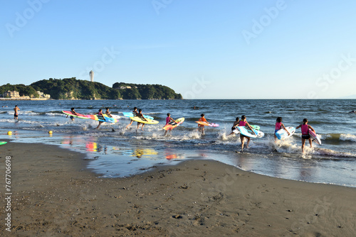片瀬海岸に並ぶ子供サーファーとカラフルなボード