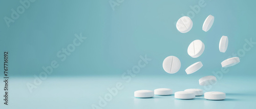 A group of white pills falling from a pill bottle, captured in mid-air