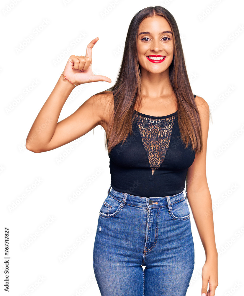 Young hispanic woman wearing casual clothes smiling and confident gesturing with hand doing small size sign with fingers looking and the camera. measure concept. Young hispanic woman wearing casual clothes smiling and confident gesturing with hand doing small size sign with fingers looking and the camera. measure concept.
