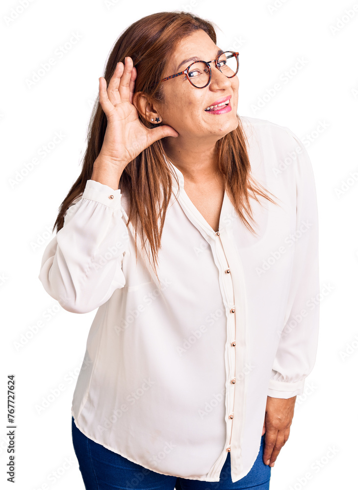 Middle age latin woman wearing casual clothes and glasses smiling with hand over ear listening an hearing to rumor or gossip. deafness concept. Middle age latin woman wearing casual clothes and glasses smiling with hand over ear listening an hearing to rumor or gossip. deafness concept.