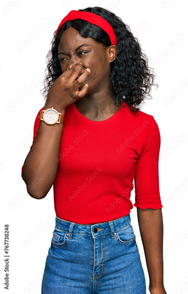 Beautiful african young woman wearing casual clothes smelling something stinky and disgusting, intolerable smell, holding breath with fingers on nose. bad smell Beautiful african young woman wearing casual clothes smelling something stinky and disgusting, intolerable smell, holding breath with fingers on nose. bad smell