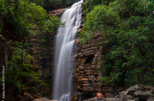 Unidentified Couple Enjoying Silky Waterfall in Lush Canyon